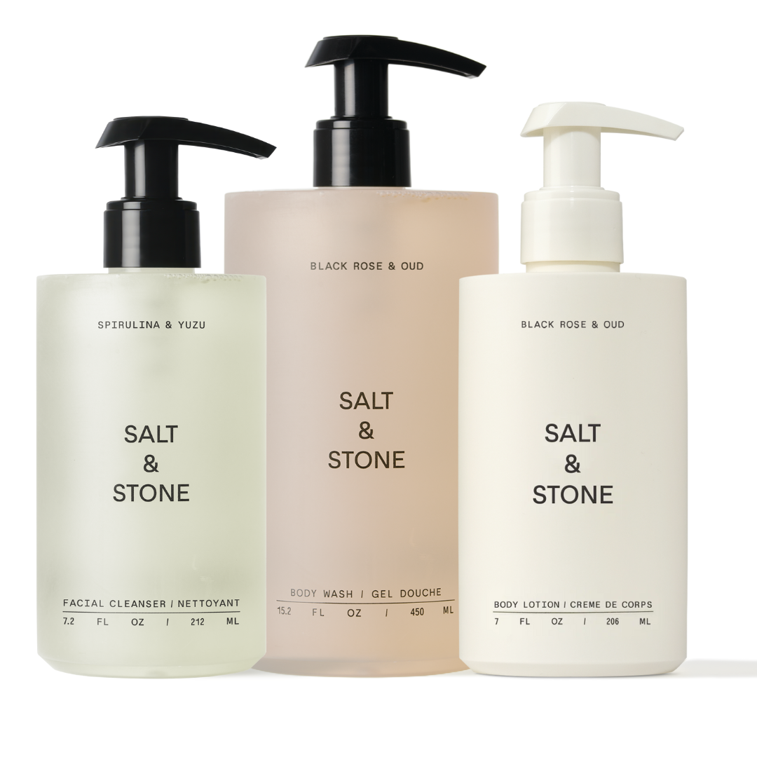 Three pump bottles labeled Salt & Stone, containing body wash, body lotion, and facial cleanser.