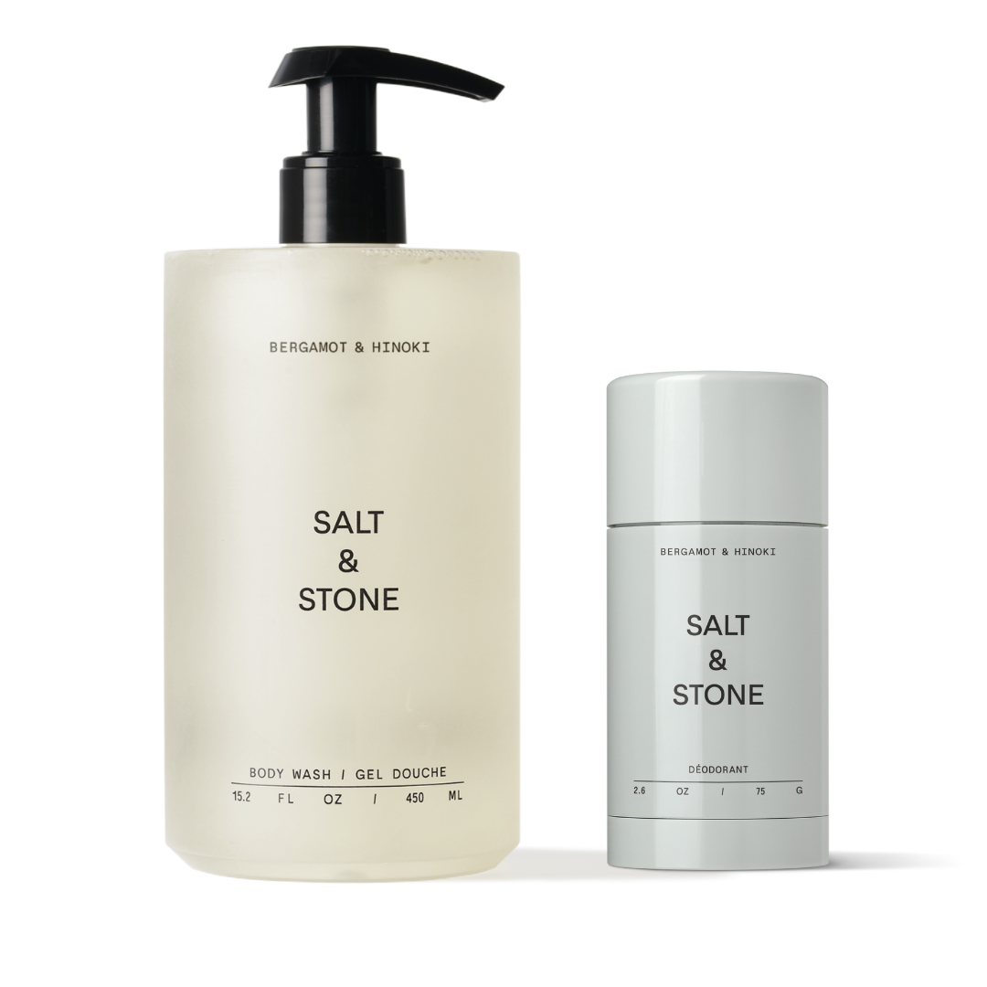 A bottle of Salt & Stone shower gel and a stick deodorant, both with a beige and white color scheme and the scent of bergamot and hinoki.
